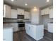 Well-lit kitchen features white cabinets, stainless steel appliances, and an island with a light granite countertop at 33 Brooklynn Trail # 181, Angier, NC 27501