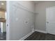 Bright laundry room with a wire rack shelf above hookups with a view of the kitchen on the other side of the doorway at 33 Brooklynn Trail # 181, Angier, NC 27501