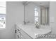 Bathroom featuring double vanity with white countertop and large mirror, illuminated by natural light at 3918 Well Fleet Dr, Fuquay Varina, NC 27526