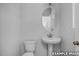 Simple half bathroom featuring a pedestal sink, toilet, and a classic framed mirror at 3918 Well Fleet Dr, Fuquay Varina, NC 27526