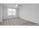 Bright bedroom with neutral carpet and ceiling fan, illuminated by a large window at 3918 Well Fleet Dr, Fuquay Varina, NC 27526