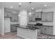 Modern kitchen with gray cabinets, black countertops, stainless steel appliances, and pendant lighting at 3918 Well Fleet Dr, Fuquay Varina, NC 27526