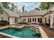 Spacious backyard deck with pool, outdoor furniture, and a charming outdoor fireplace at 403 Granville Rd, Chapel Hill, NC 27514