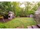 Spacious backyard with lush green grass, a playhouse, and mature trees providing shade and privacy at 403 Granville Rd, Chapel Hill, NC 27514