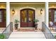 Inviting front entrance with double wood doors, lantern sconces and elegant porch setting at 403 Granville Rd, Chapel Hill, NC 27514