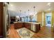 Open kitchen with wood floors, large island, stainless appliances, and an adjoining living area at 403 Granville Rd, Chapel Hill, NC 27514