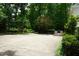 Expansive backyard featuring mature trees, manicured bushes, and a concrete parking area, offering privacy and space at 4113 Oak Park Rd, Raleigh, NC 27612