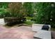A brick patio leads to a scenic backyard with lush greenery and a charming red gazebo, perfect for relaxation at 4113 Oak Park Rd, Raleigh, NC 27612