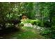Lush backyard with trees, greenery, and a red gazebo enhancing the view of this unique property at 4113 Oak Park Rd, Raleigh, NC 27612