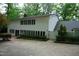 Back of home featuring white siding, a dark roof, and ample windows for natural light, overlooking a concrete patio at 4113 Oak Park Rd, Raleigh, NC 27612