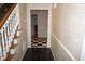 Welcoming foyer with black slate tile, a staircase with white railings and light beige, textured wallpaper at 4113 Oak Park Rd, Raleigh, NC 27612