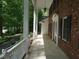 Covered front porch featuring tiled flooring and white columns, offering a relaxing outdoor space at 4113 Oak Park Rd, Raleigh, NC 27612