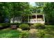Beautifully landscaped front yard with mature trees, lush lawn, and a charming brick walkway at 4113 Oak Park Rd, Raleigh, NC 27612