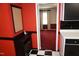 Hallway features a bold red wall, a black cabinet with a cork board, and checkered floors leading to another room at 4113 Oak Park Rd, Raleigh, NC 27612