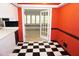 Kitchen with a doorway view of the bright sunroom featuring a tiled floor and a window seat with multiple windows at 4113 Oak Park Rd, Raleigh, NC 27612