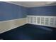 Cozy living room featuring built-in display cabinetry and plush blue carpeting at 4113 Oak Park Rd, Raleigh, NC 27612