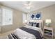 Staged bedroom with neutral walls, blue decor accents, and two windows at 420 Marsh Landing Dr, Holly Springs, NC 27540
