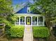 Charming blue craftsman home with a bright yellow front door, covered porch, and landscaped front yard at 420 Marsh Landing Dr, Holly Springs, NC 27540