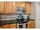 Well-lit kitchen featuring stainless steel appliances, wooden cabinetry, and granite countertops at 420 Marsh Landing Dr, Holly Springs, NC 27540
