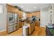 Bright kitchen with stainless steel appliances, wooden cabinetry, and a black island, offering ample space for cooking and storage at 420 Marsh Landing Dr, Holly Springs, NC 27540