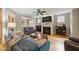 Cozy living room with a fireplace, TV, wood floors, and comfortable blue sofas perfect for relaxing and entertaining at 420 Marsh Landing Dr, Holly Springs, NC 27540