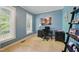 Bright office with natural light featuring a black desk, shelving, and soothing blue walls at 420 Marsh Landing Dr, Holly Springs, NC 27540