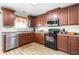 Modern kitchen with stainless steel appliances, ample cabinet space, and hardwood floors at 4221 Northrop Dr, Haw River, NC 27258