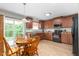 Eat-in kitchen featuring wooden cabinets, modern appliances, hardwood floors, and a sliding glass door at 4221 Northrop Dr, Haw River, NC 27258