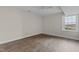 A large bedroom with wood laminate floors and a window letting in natural light at 4309 Birmingham Way, Raleigh, NC 27604
