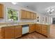 Kitchen featuring oak cabinets, a double sink and a white dishwasher at 4309 Birmingham Way, Raleigh, NC 27604