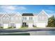 Charming townhome showcases a contemporary facade with stone accents, a garage, and lush landscaping at 5017 Shipper Ln, Durham, NC 27703