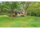View of the rear of the house featuring mature trees and grass at 502 Hiddenbrook Dr, Durham, NC 27703