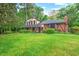 Attractive Tudor-style home with brick accents, and a chimney nestled in a lush green landscape at 502 Hiddenbrook Dr, Durham, NC 27703