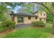 Home's exterior shows large sliding glass door and a stone patio surrounded by beautiful landscaping at 502 Hiddenbrook Dr, Durham, NC 27703