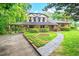 Charming Tudor-style home with lush landscaping, a covered driveway, and a beautiful stone walkway at 502 Hiddenbrook Dr, Durham, NC 27703