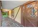 Covered front porch with stone floor tiles leading to an elegant, glass-paned front door and windows at 502 Hiddenbrook Dr, Durham, NC 27703