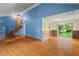 Open living room featuring hardwood floors, staircase, vaulted ceiling, and sliding glass doors to the backyard at 502 Hiddenbrook Dr, Durham, NC 27703
