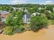 Aerial view of backyard, lake, and two story home surrounded by mature trees at 510 N Waters Edge Dr, Durham, NC 27703
