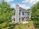 Two-story home featuring neutral siding, a chimney, patio, and surrounded by mature trees at 510 N Waters Edge Dr, Durham, NC 27703