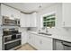 Bright kitchen with stainless steel appliances, white cabinetry, and a window view at 510 N Waters Edge Dr, Durham, NC 27703