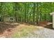 The backyard has a storage shed and wooden deck surrounded by forest views at 524 Preston Andrews Rd, Bahama, NC 27503