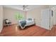Sunlit bedroom features hardwood floors, a comfortable bed, and a relaxing sitting area near the window at 524 Preston Andrews Rd, Bahama, NC 27503