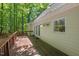 A wooden deck is attached to the side of a light yellow home with a view of the woods at 524 Preston Andrews Rd, Bahama, NC 27503