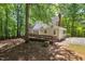 View of the house with a chimney and a wooden deck nestled within a wooded yard at 524 Preston Andrews Rd, Bahama, NC 27503