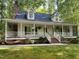 Charming home with a welcoming front porch, lush landscaping, and a brick chimney at 524 Preston Andrews Rd, Bahama, NC 27503
