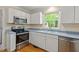 Kitchen with stainless steel appliances, bright natural light, and views of the backyard at 524 Preston Andrews Rd, Bahama, NC 27503