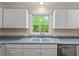 Kitchen sink and stainless steel dishwasher with a view to the trees outside at 524 Preston Andrews Rd, Bahama, NC 27503