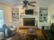 Cozy living room featuring a brick fireplace, custom built-ins, and hardwood floors at 524 Preston Andrews Rd, Bahama, NC 27503