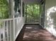 View of a screened porch with white rails overlooking lush, wooded backyard at 524 Preston Andrews Rd, Bahama, NC 27503