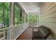 Charming screened porch with a wicker bench and serene views of the surrounding green landscape at 524 Preston Andrews Rd, Bahama, NC 27503